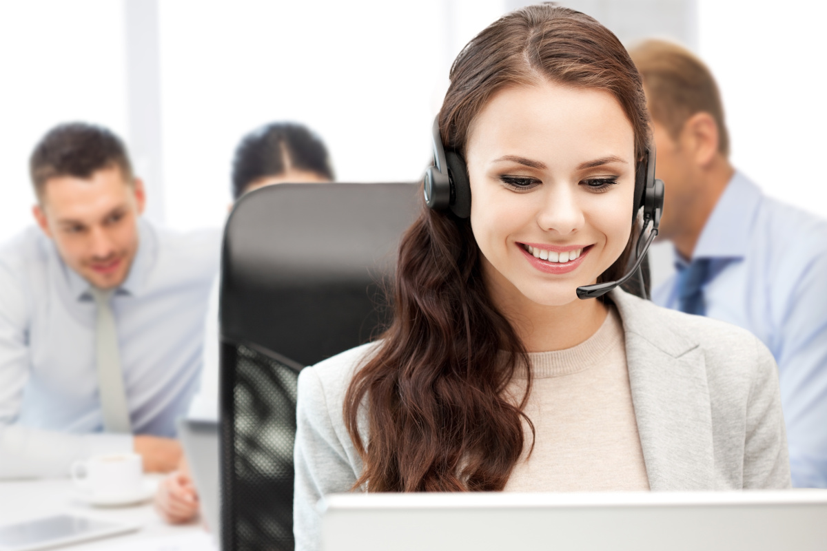 A woman using a headset and smiling