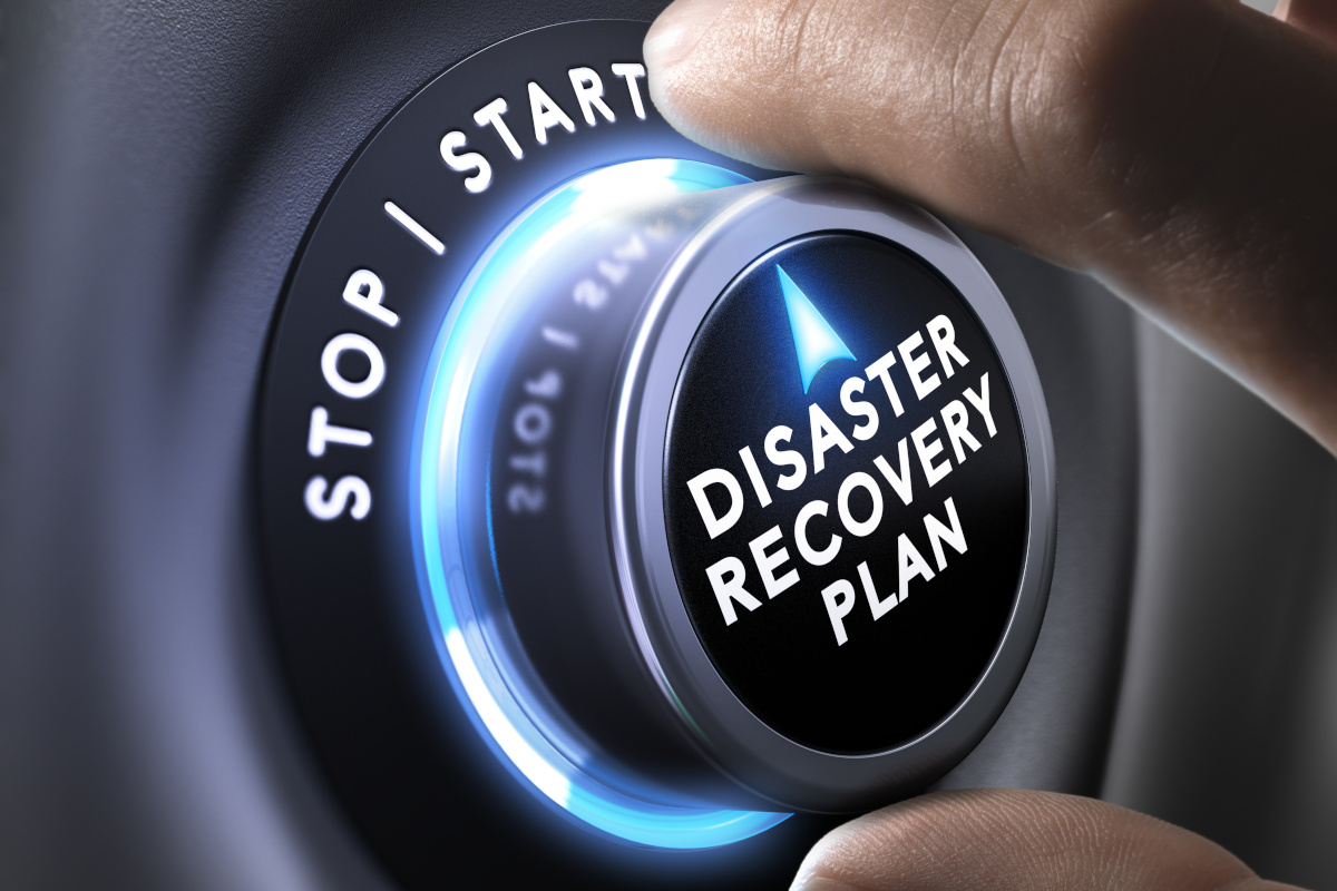 A hand turning a dial that reads Disaster Recovery Plan