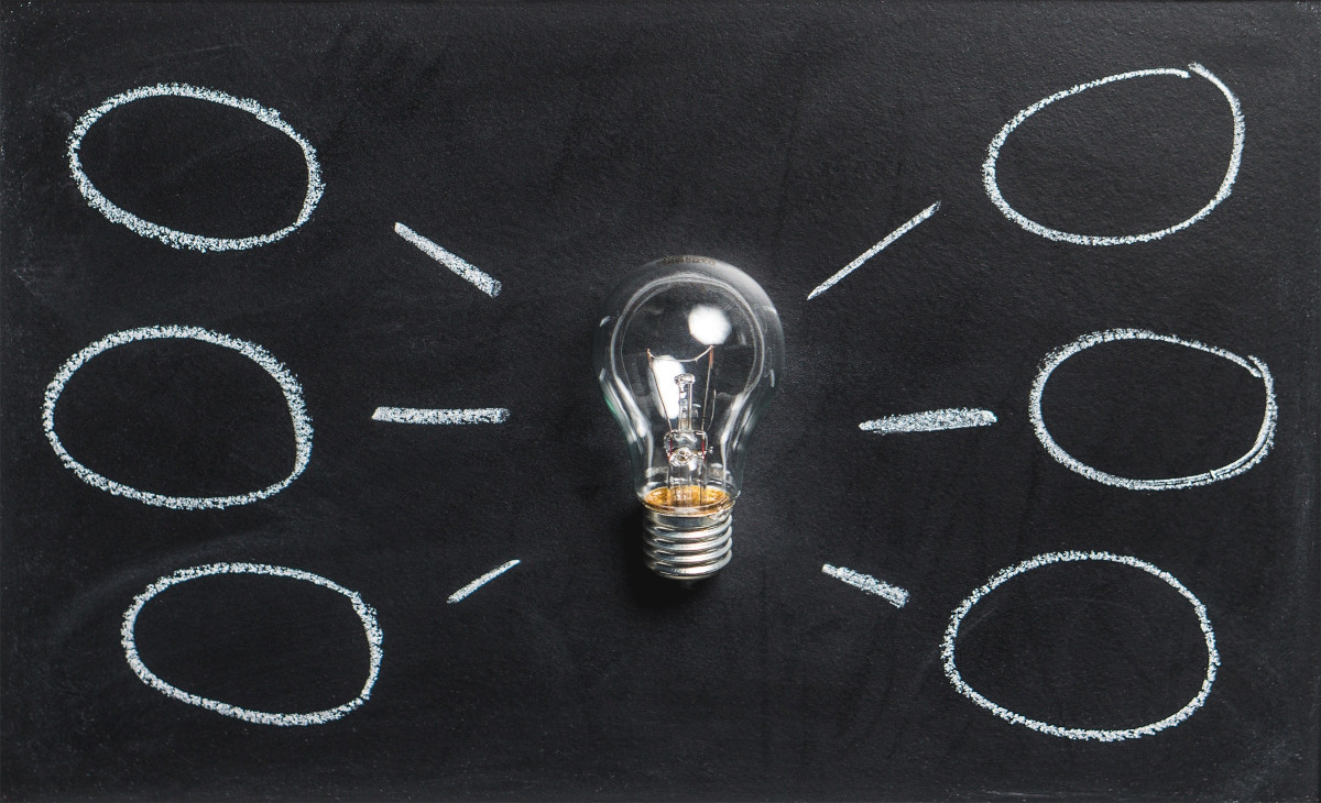 A lightbulb on a chalkboard with chalk bubbles connected to the lightbulb with lines