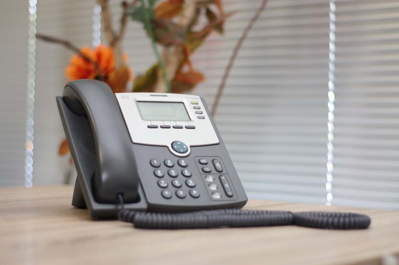Business telephone system in forefront on desk