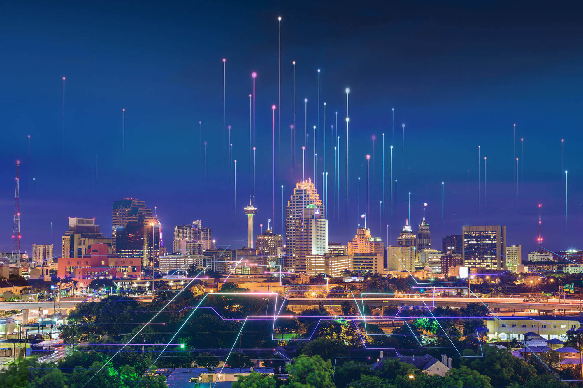 Cityscape at night with neon light streams along streets and heading into the sky