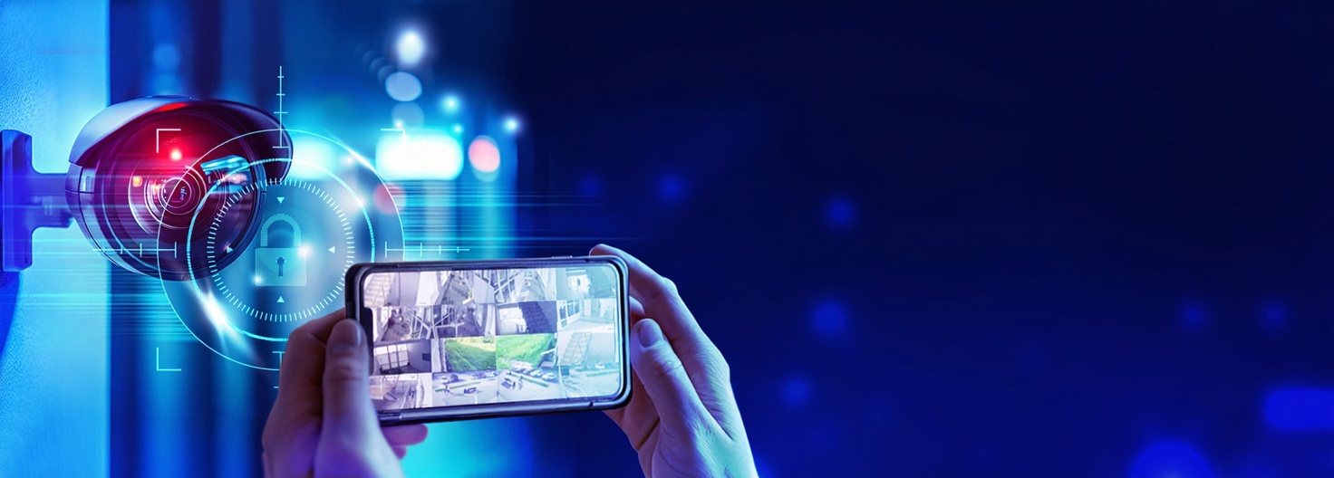 Hands holding up a mobile phone in landscape mode showing multiple surveillance cameras on a feed